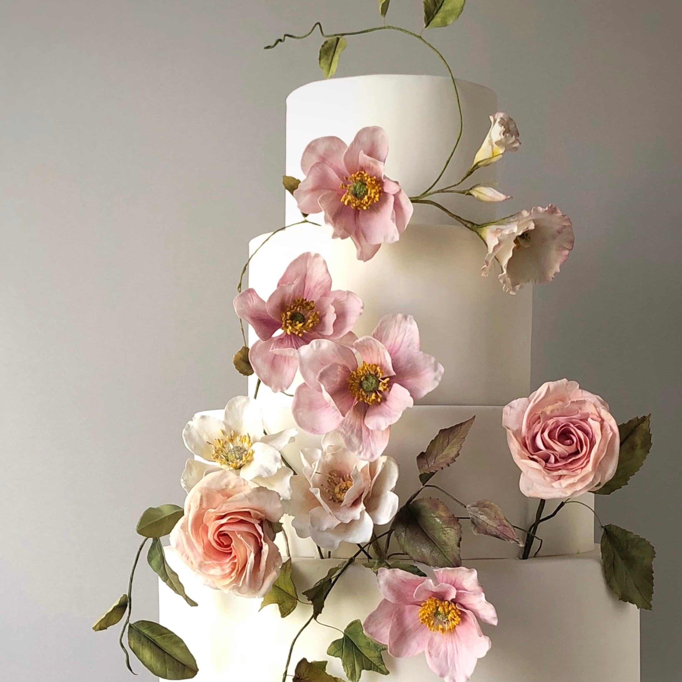 Custom celebration cake by Natasja Sadi, blending elegant design aesthetics with detailed sugar flowers to mark a special occasion.