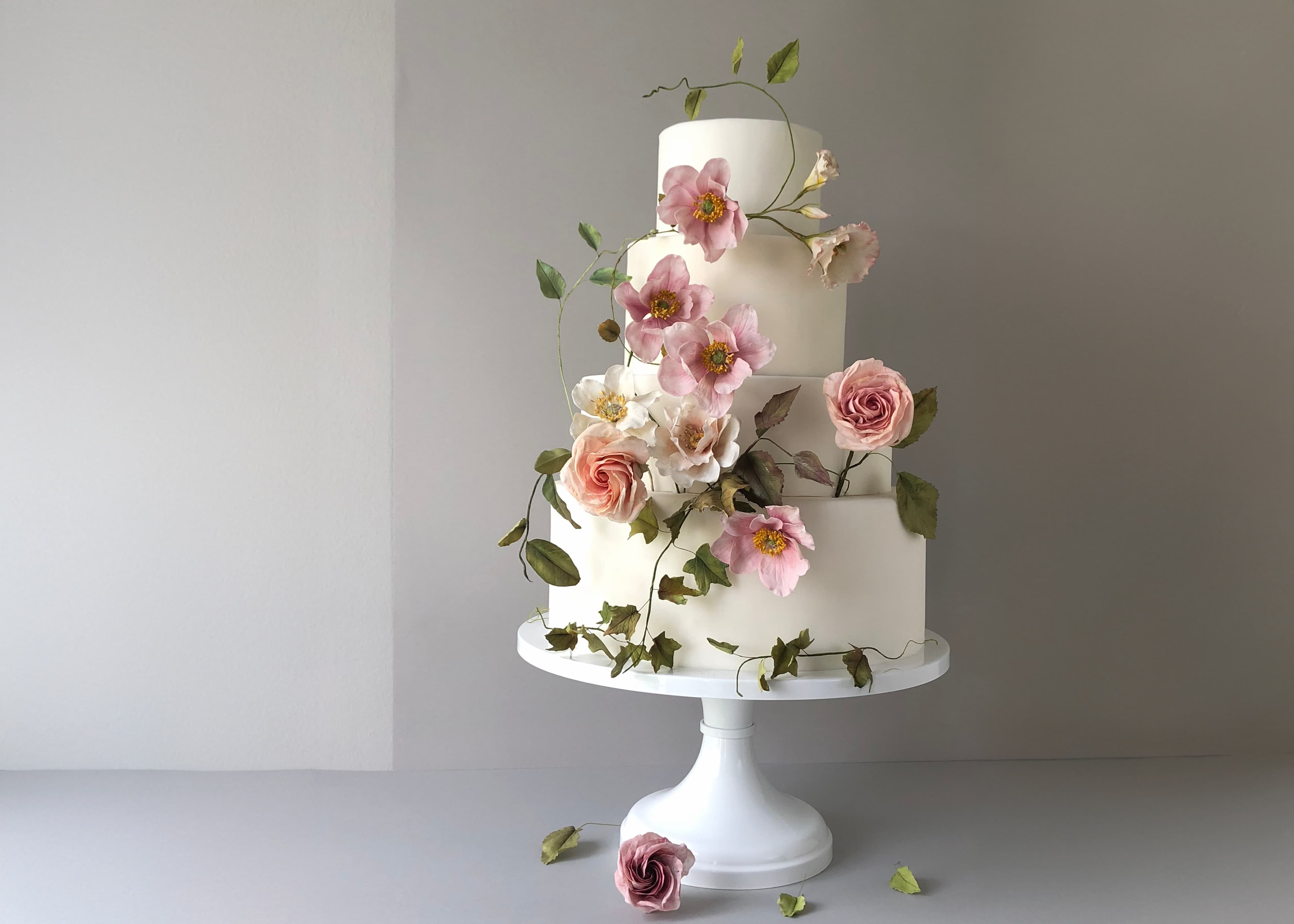 Close-up of intricate sugar flowers delicately placed on a custom cake designed by Natasja Sadi